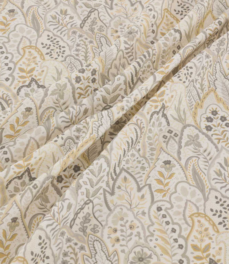 Hitherhill Gull floral fabric arranged in soft, flowing folds, showcasing its layered botanical pattern of stylised leaves, delicate flowers and branching foliage in muted grey, taupe and pale gold tones against an ivory background.