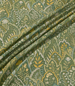 Hitherhill Kelp floral fabric arranged in soft, flowing folds, showcasing its detailed botanical pattern of layered foliage, delicate flowers and decorative leaf motifs in deep forest green, olive, golden yellow, muted blue and cream, with the folds highlighting the fabric's drape and printed detail.