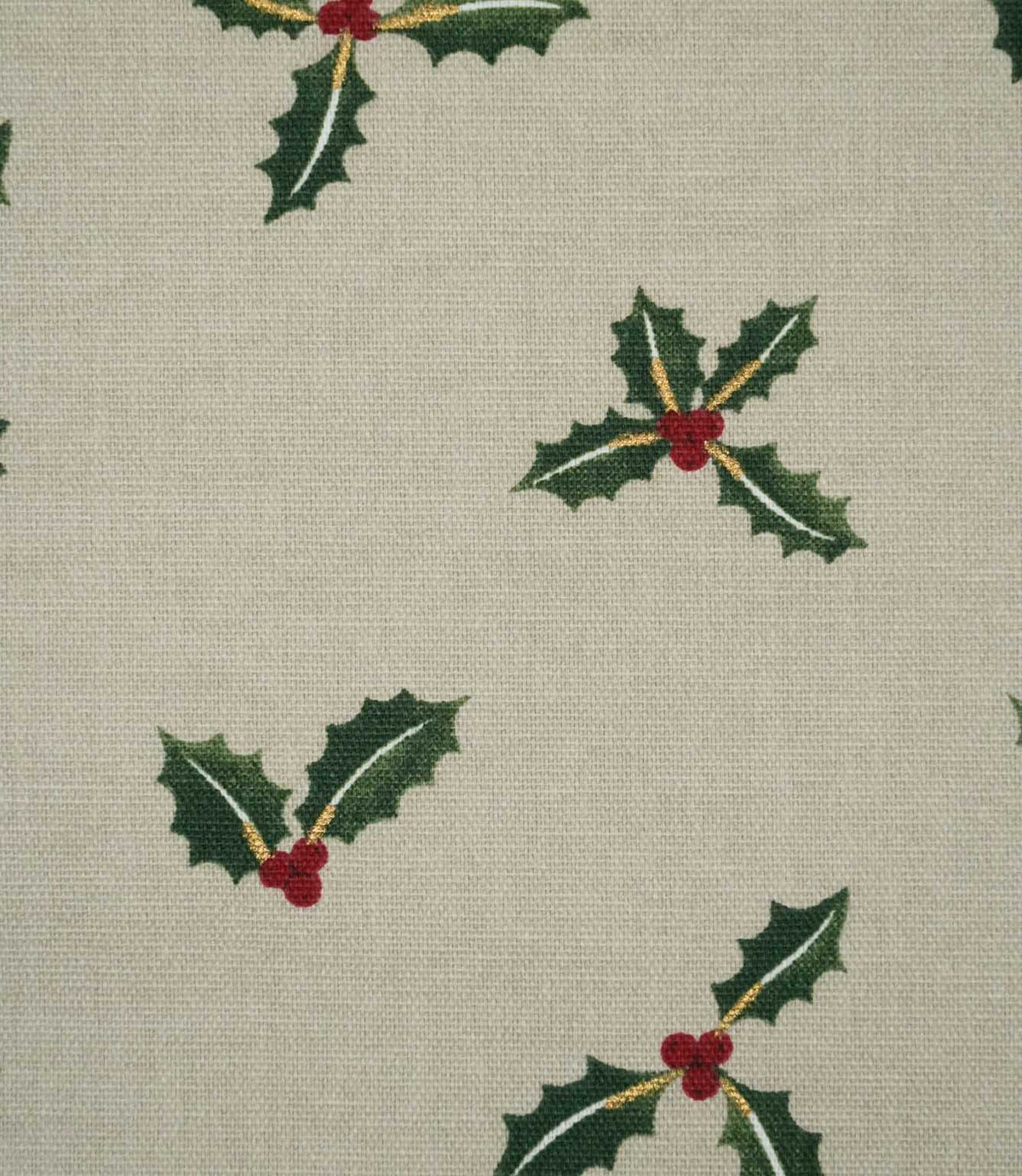 Close-up of Holly and Berry Stone fabric showing festive green holly leaves, red berries and fine gold detailing on a textured neutral woven ground.