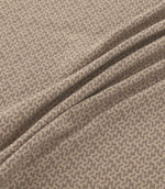 Horton Rockport grey-brown and beige geometric fabric draped in soft folds, highlighting its intricate repeating design and woven texture.