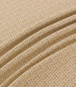 Horton Sandytan golden sand and cream geometric fabric arranged in diagonal folds, showing its textured weave and repeating pattern.