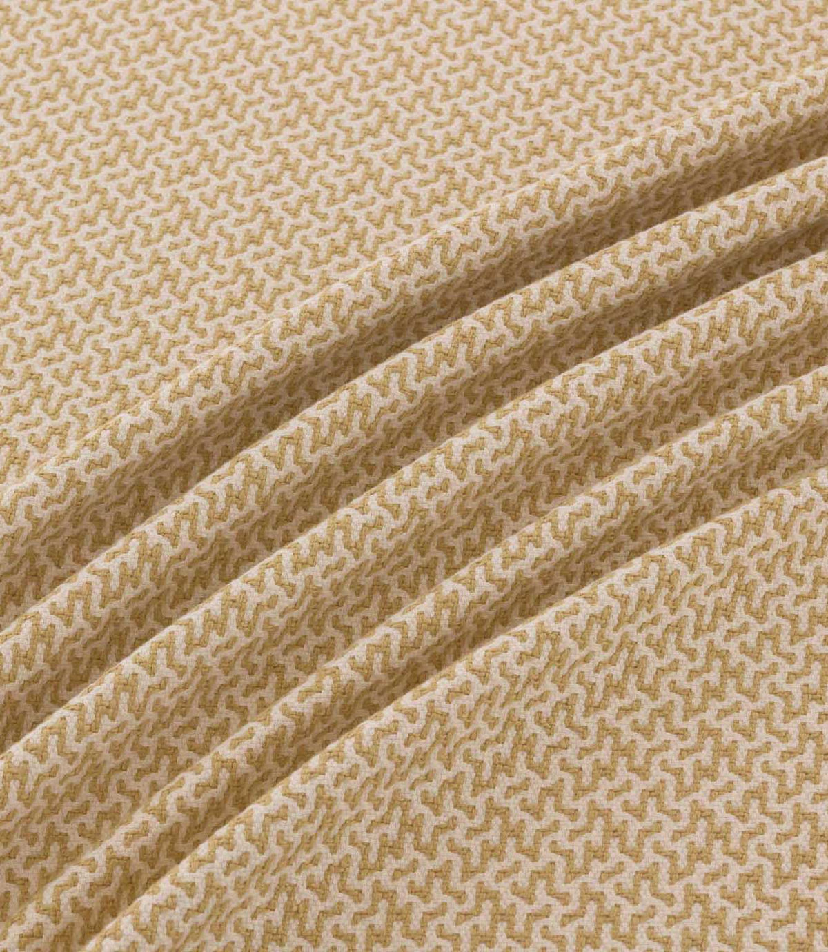 Horton Sandytan golden sand and cream geometric fabric arranged in diagonal folds, showing its textured weave and repeating pattern.