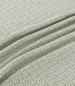 Horton Seafoam pale green and ivory geometric fabric draped in gentle folds, highlighting its small-scale repeating design and woven texture.