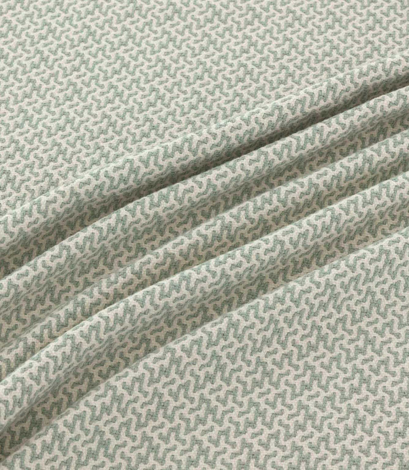 Horton Seafoam pale green and ivory geometric fabric draped in gentle folds, highlighting its small-scale repeating design and woven texture.