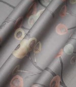 Ichiyo fabric arranged in soft folds, displaying its flowing grey branches and scattered pastel pink, cream and mint green circular floral motifs.
