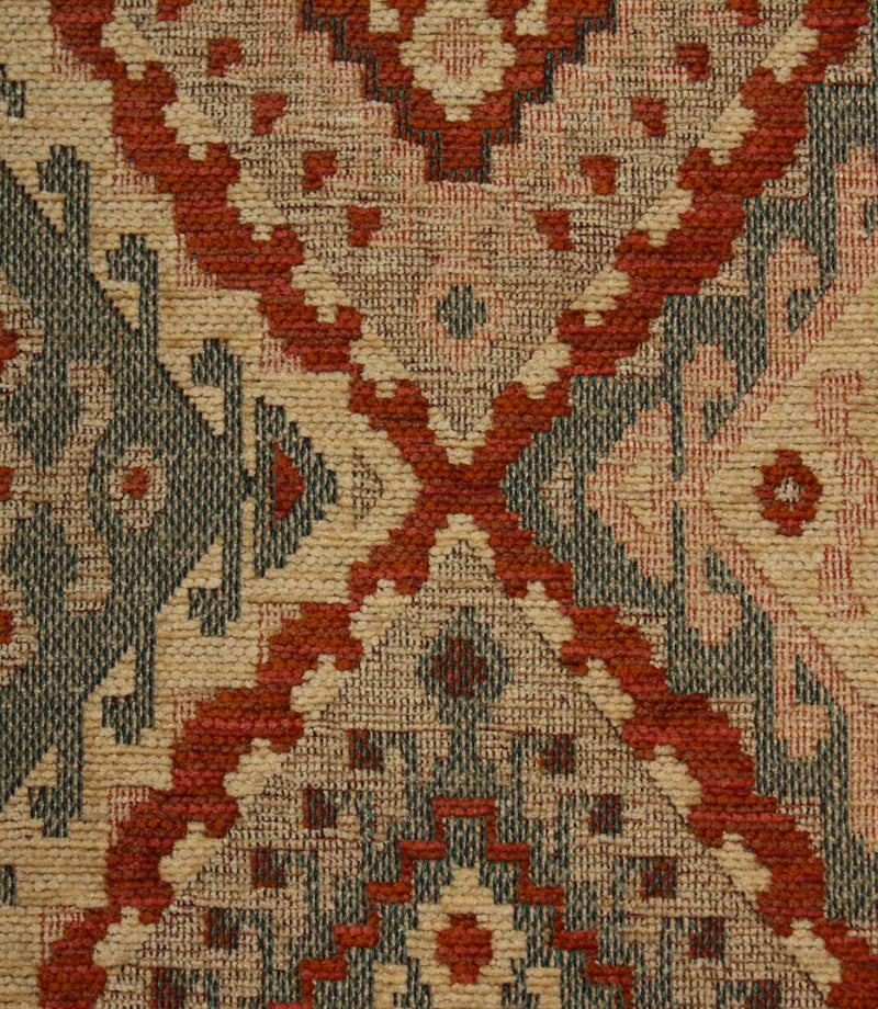 Close-up of a patterned geometric fabric with red, beige, and brown colours.