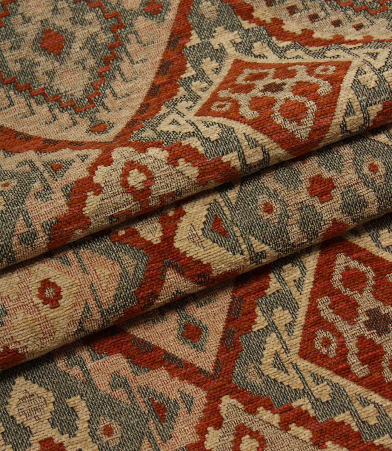 Close-up of patterned geometric fabric with red, beige, and grey colours.