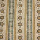Decorative stripe fabric in muted mustard, slate blue, and taupe with repeating floral vine motifs on a natural background.