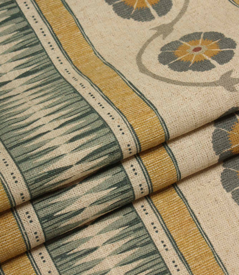 Folded striped fabric featuring decorative geometric panels and repeating floral motifs in muted heritage-inspired colours.