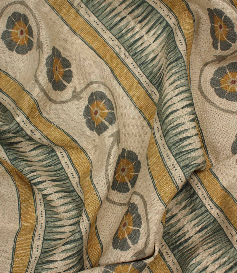 Draped woven-look fabric with stylised floral trails and layered stripe patterns in ochre, blue-grey, and natural linen shades.