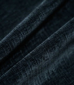 Insernia Velvet Night fabric arranged in flowing folds, showcasing its deep charcoal navy colour, gently mottled velvet texture and subtle sheen as the light catches the surface.