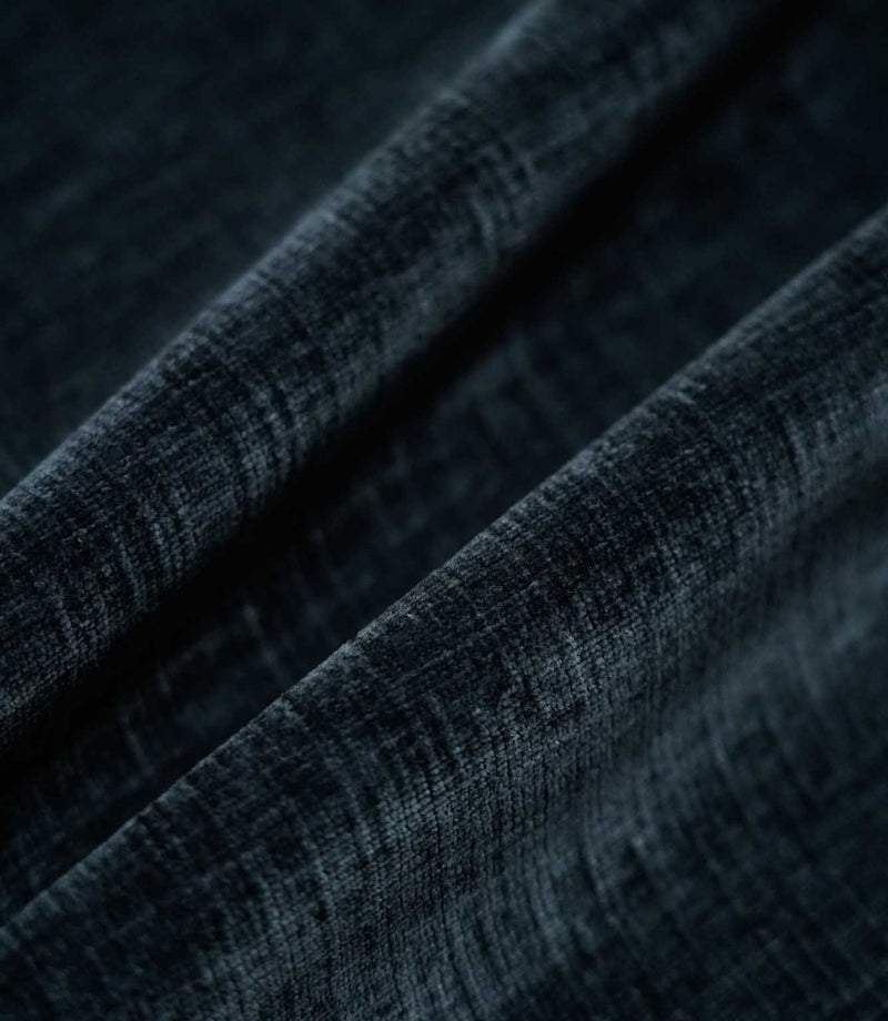Insernia Velvet Night fabric arranged in flowing folds, showcasing its deep charcoal navy colour, gently mottled velvet texture and subtle sheen as the light catches the surface.