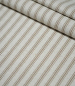 Detailed view of beige ticking stripe fabric arranged in soft folds, highlighting the textured weave and repeating neutral vertical stripe design.