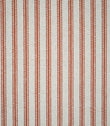 Close-up of Linen Ticking Burnt Orange fabric featuring evenly spaced burnt orange woven stripes on a textured natural cream background.