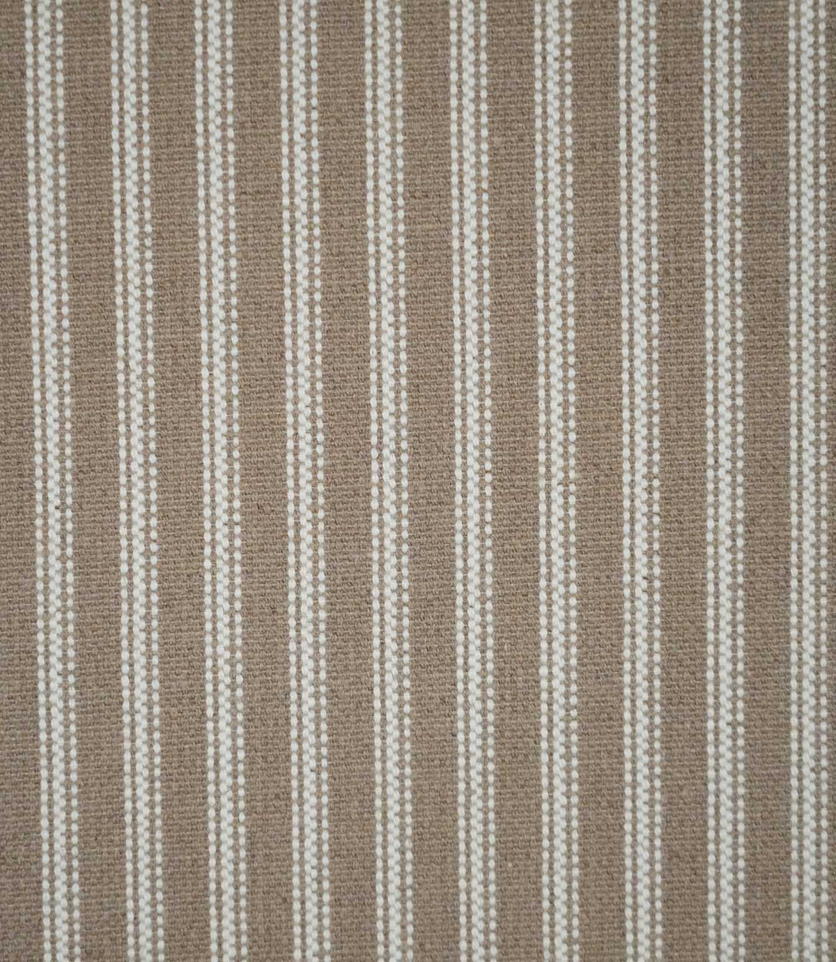 Natural ticking stripe fabric with evenly spaced ivory woven stripes on a warm taupe-beige background, showing the classic striped design and textured weave.