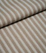 Close-up of natural ticking stripe fabric arranged in a soft fold, highlighting the fine ivory stripes and subtle woven texture.