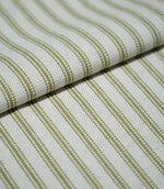 Folded sage green ticking stripe fabric showing the repeating narrow stripes and textured cream weave in close detail.