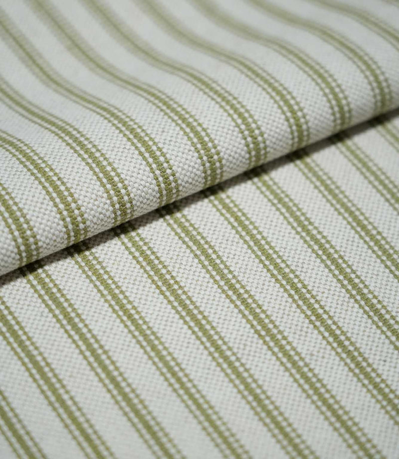 Folded sage green ticking stripe fabric showing the repeating narrow stripes and textured cream weave in close detail.