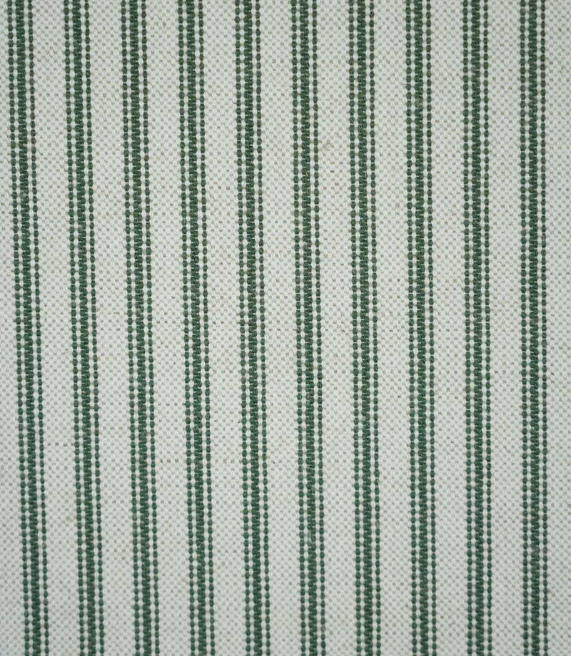 Close-up of sap green ticking stripe fabric with narrow woven green stripes on a natural cream background, showing the textured weave and classic striped design.