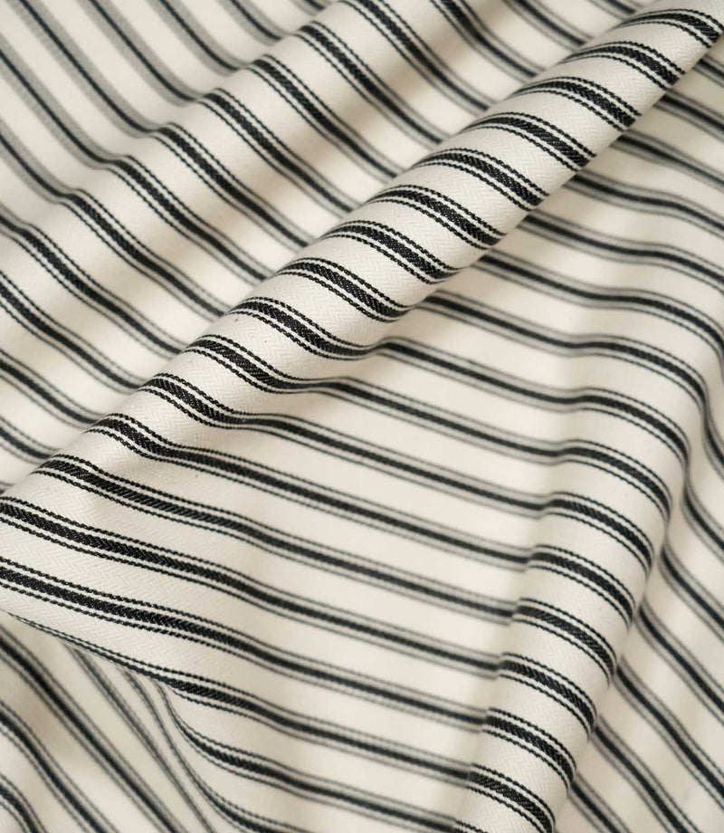 JF Ticking Black fabric draped in soft folds, highlighting the natural drape, classic black ticking stripes and subtle herringbone texture.