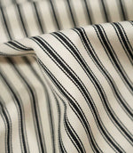 Detailed close-up of JF Ticking Black fabric showing the cream herringbone weave, textured black ticking stripes and soft natural drape.