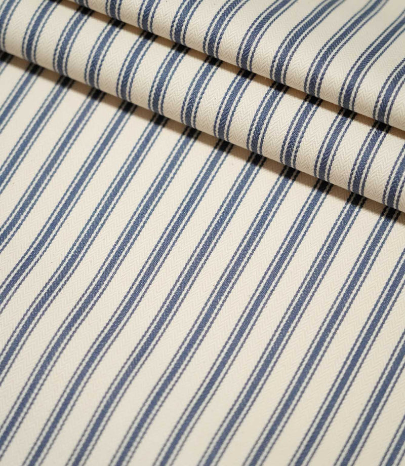 JF Ticking Blue striped fabric laid flat and neatly folded, showing the repeating blue ticking stripe design and textured cream weave.