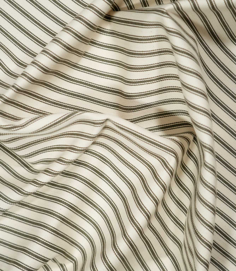Draped JF Ticking Forest fabric in soft folds, showing the classic green and ivory ticking stripe design and natural woven texture.