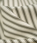 Macro close-up of JF Ticking Forest striped fabric, highlighting the forest green woven stripes, ivory herringbone texture and soft drape.