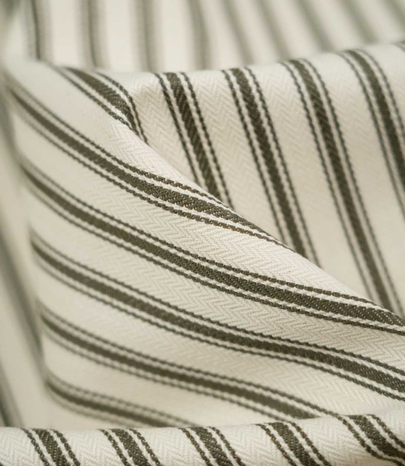 Macro close-up of JF Ticking Forest striped fabric, highlighting the forest green woven stripes, ivory herringbone texture and soft drape.