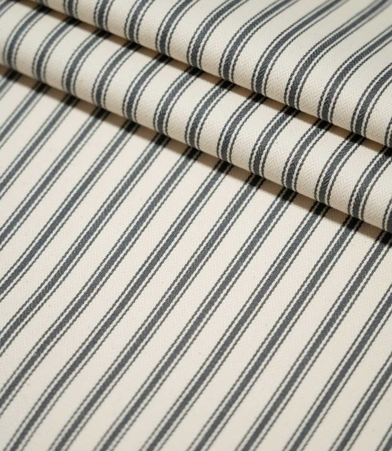JF Ticking Grey striped fabric laid flat and neatly folded, showing the repeating grey ticking stripe pattern and textured cream weave.