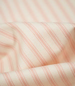 Detailed close-up of JF Ticking Pink fabric showing the soft blush pink woven ticking stripes and fine herringbone texture on a cream ground.