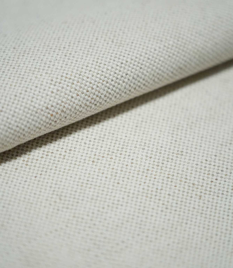 Close-up of JF Ticking Plain Natural fabric folded over itself, revealing its substantial woven texture, ivory cream colour and fine beige yarn detailing.