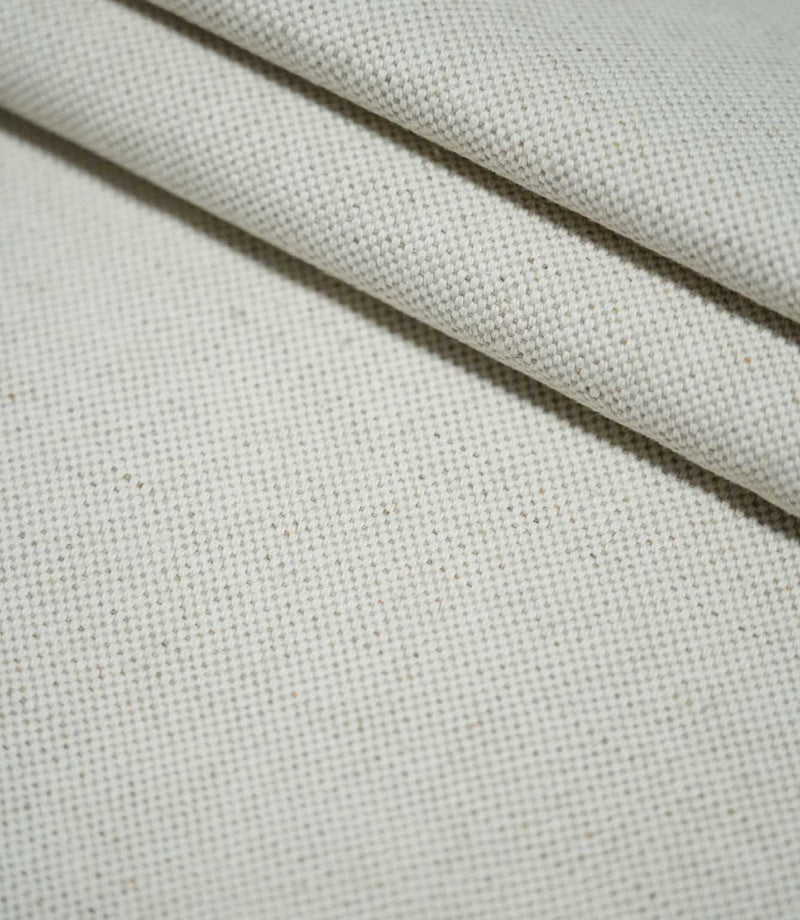 JF Ticking Plain Natural fabric arranged in overlapping folds, showing the plain weave construction, natural cream colouring and softly textured surface.