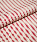 Close-up of folded JF Ticking Red fabric showing the repeating red ticking stripes and fine herringbone texture of the cream background.