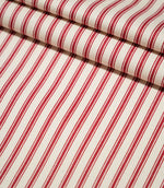 JF Ticking Red striped fabric arranged in neat folds, showing the bold repeating red stripes and textured cream herringbone weave.
