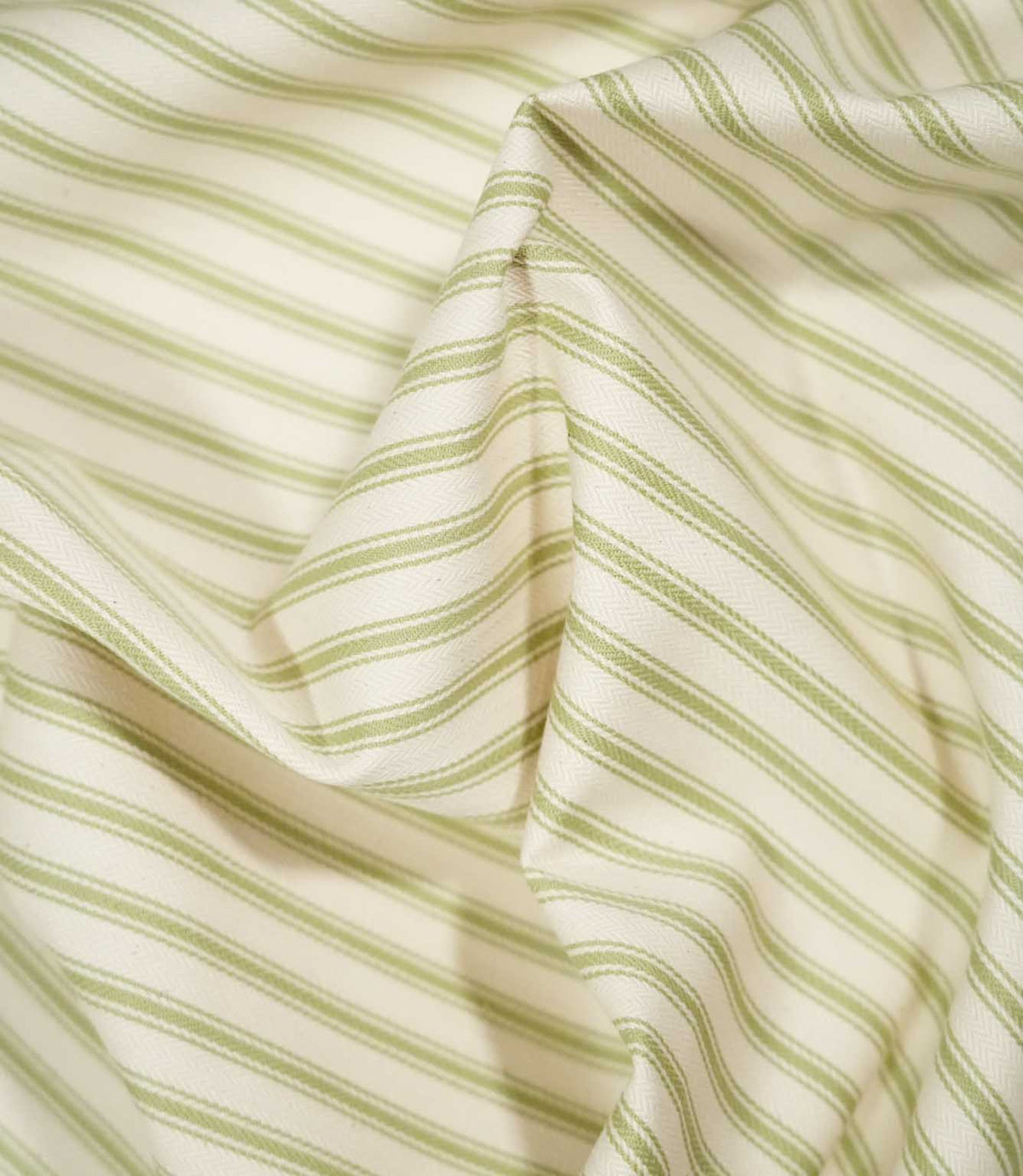 JF Ticking Sage Green fabric draped in soft folds, highlighting the classic sage green ticking stripe design, woven texture and natural drape.