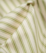 Detailed close-up of JF Ticking Sage Green fabric showing the woven green ticking stripes and subtle herringbone texture against a warm cream background.