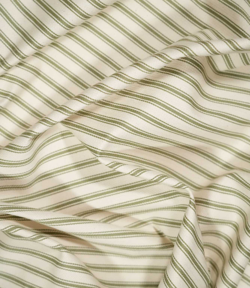 JF Ticking Sap Green fabric draped in soft folds, highlighting the classic olive green ticking stripe pattern, woven texture and natural drape.