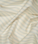 JF Ticking Seaspray fabric draped in soft folds, showing the pale blue ticking stripe pattern, cream ground and natural movement of the woven fabric.