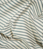 JF Ticking Teal striped fabric draped in loose folds, showing the classic teal ticking design, cream background and natural movement of the fabric.