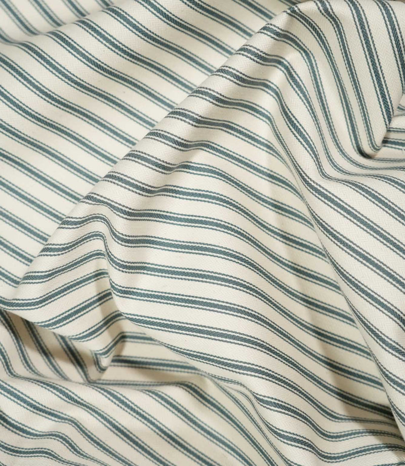 JF Ticking Teal striped fabric draped in loose folds, showing the classic teal ticking design, cream background and natural movement of the fabric.