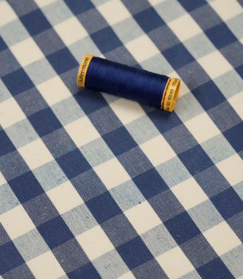 Blue and ivory gingham fabric with matching navy thread, ideal for sewing, quilting, dressmaking and home décor projects.