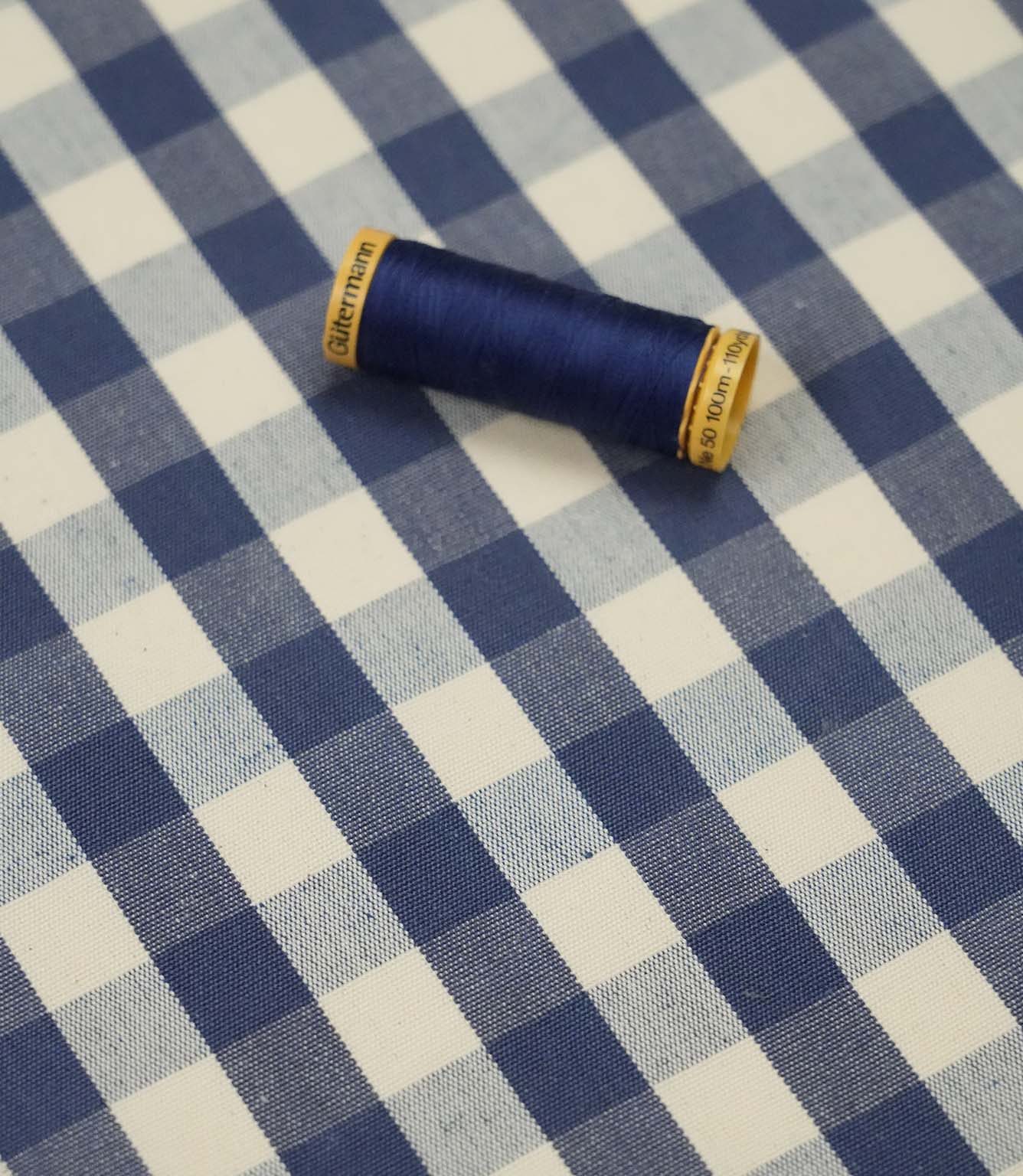 Blue and ivory gingham fabric with matching navy thread, ideal for sewing, quilting, dressmaking and home décor projects.