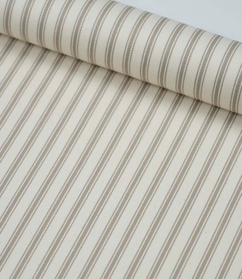 Rolled beige ticking stripe fabric highlighting the elegant neutral stripes and soft woven finish.