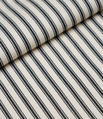 Folded black ticking stripe fabric showcasing the timeless striped pattern and premium woven finish.
