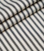 Layered folds of black ticking stripe fabric displaying the fine herringbone weave and classic striped design.