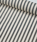 Rolled black ticking stripe fabric highlighting the bold monochrome stripes and subtle woven texture.