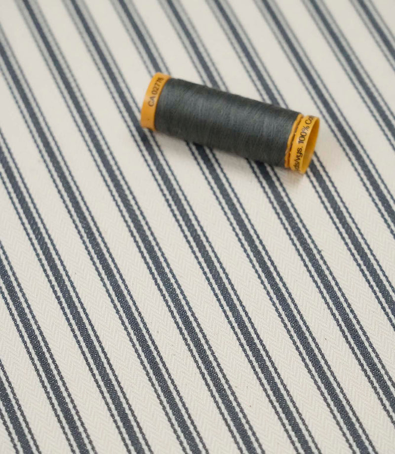 Grey ticking stripe fabric with matching grey thread, ideal for upholstery, curtains, blinds and sewing projects.