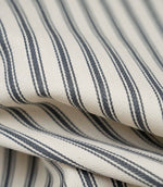 Close-up detail of grey ticking stripe fabric showing the fine woven texture and elegant grey stripe pattern.