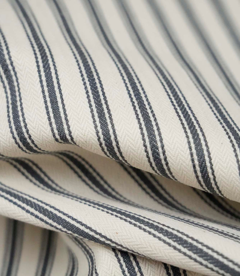 Close-up detail of grey ticking stripe fabric showing the fine woven texture and elegant grey stripe pattern.
